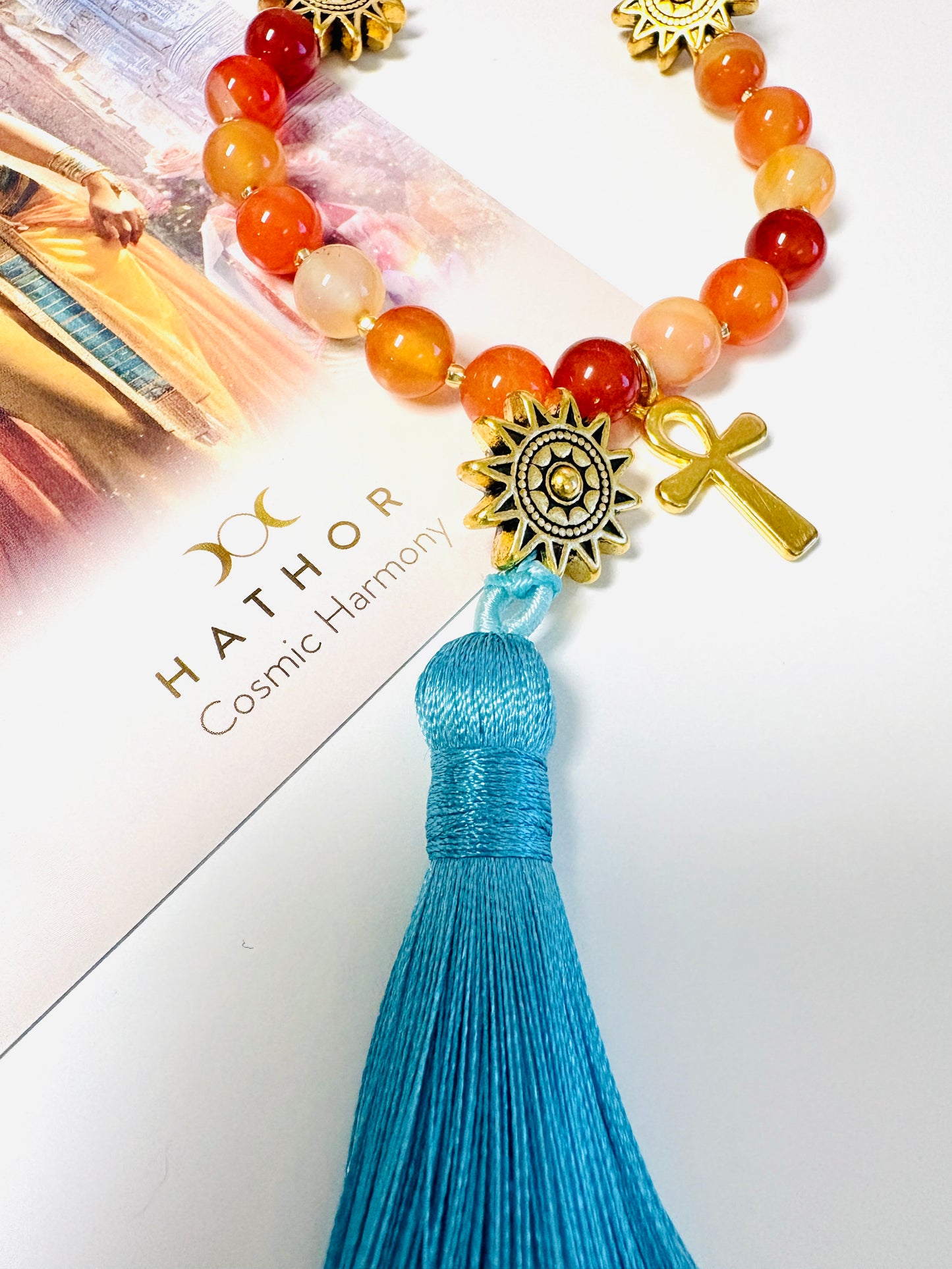 Close up of Goddess Hathor mala necklace sky blue tassel with carnelian beads and gold sun and ankh charms