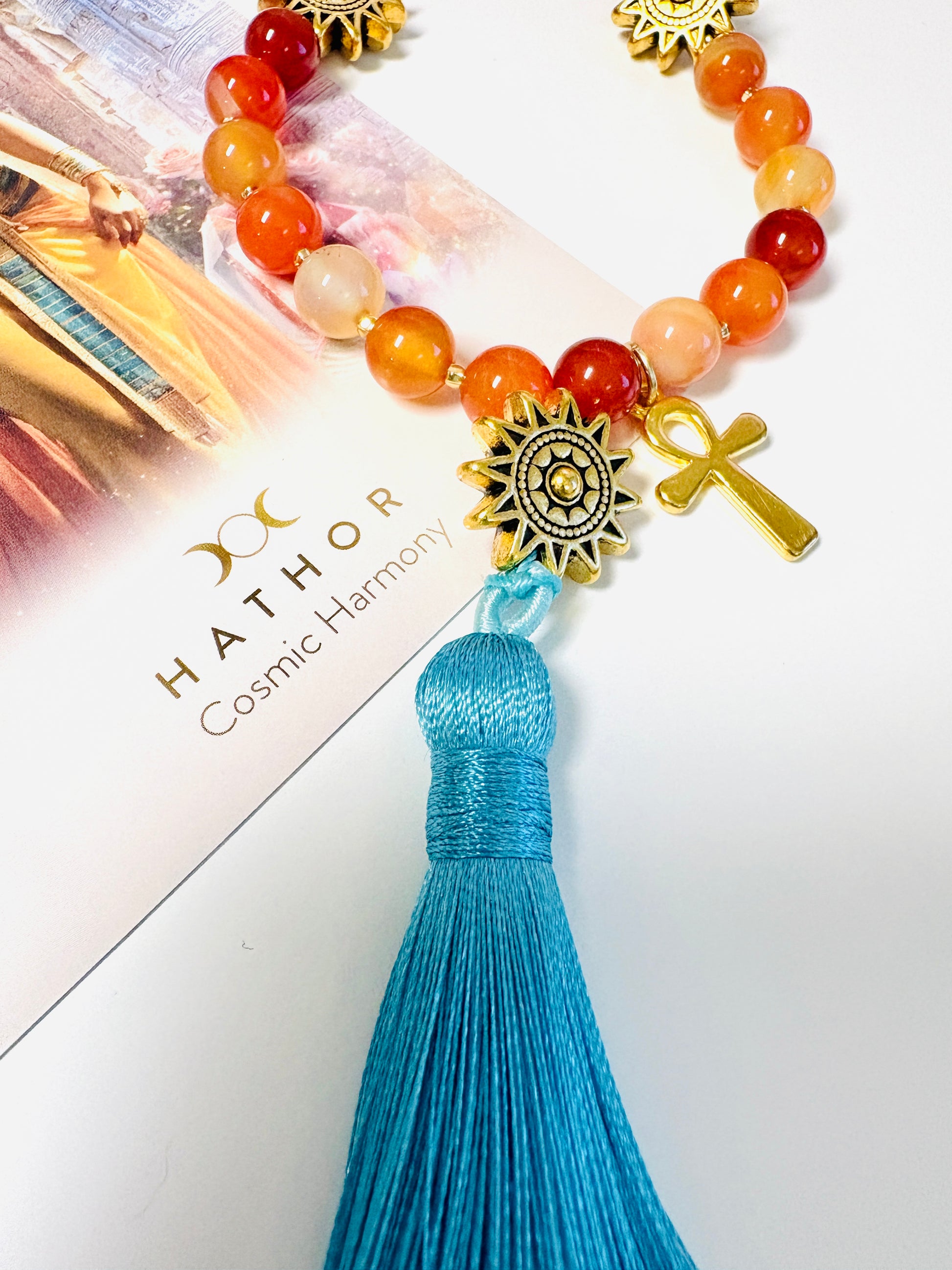 Close up of Goddess Hathor mala necklace sky blue tassel with carnelian beads and gold sun and ankh charms
